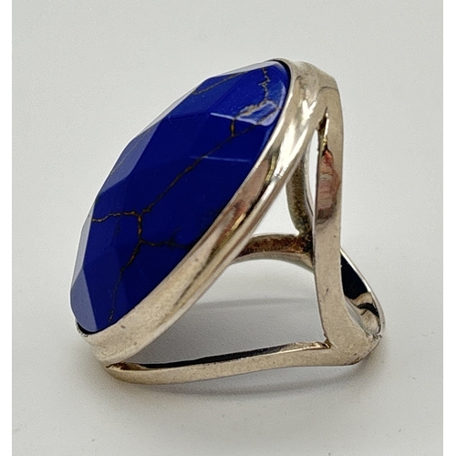 1108 - A large silver ring set with an oval faceted blue coloured stone. Stone approx. 3.5 x 2.5cm. Ring si... 