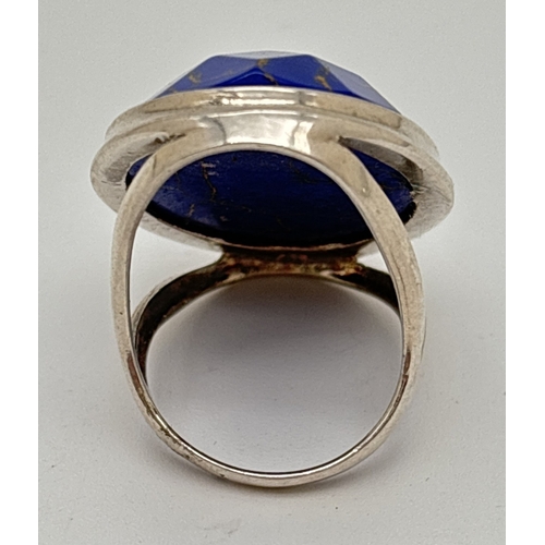 1108 - A large silver ring set with an oval faceted blue coloured stone. Stone approx. 3.5 x 2.5cm. Ring si... 