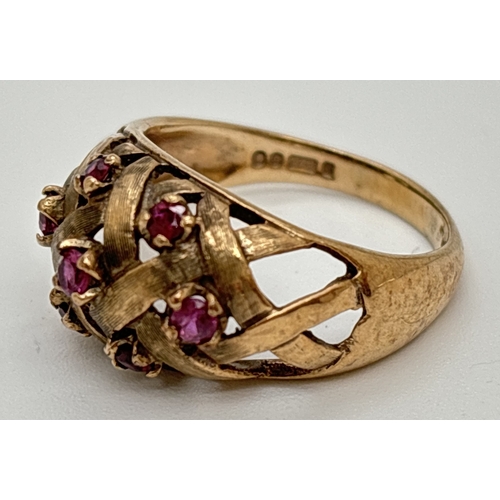 1001 - A vintage 9ct gold dome style ring with lattice work design set with 7 small round cut rubies. Hallm... 