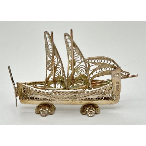 1169 - A small 925 silver filigree figurine of a boat with hinged moving tiller. Freestanding on filigree f... 