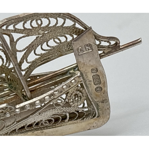 1169 - A small 925 silver filigree figurine of a boat with hinged moving tiller. Freestanding on filigree f... 