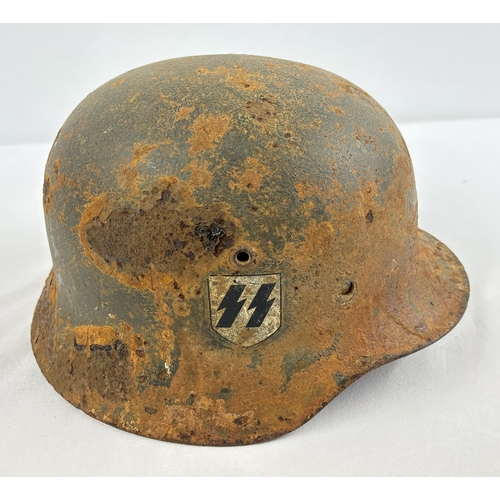 1210 - M35 German steel helmet bearing early version decals of the Waffen SS. With remains of apple green p... 