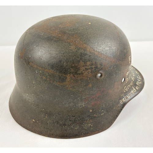 1213 - M40 German steel helmet shell bearing later painted inscription to effect it was recovered from the ... 