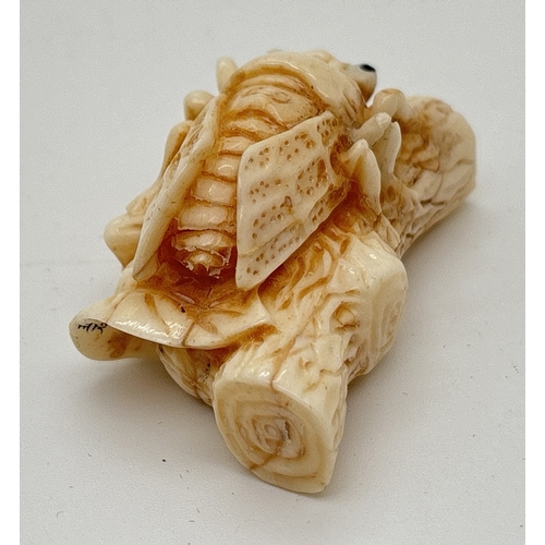 1283 - A signed Chinese netsuke modelled as a flying insect resting on a branch, possibly bone. Engraved si... 