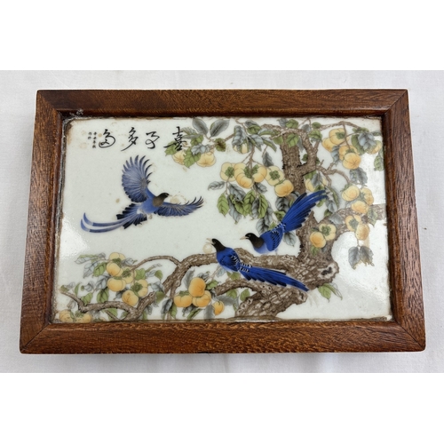 1290 - A Chinese porcelain and wood stand. Central ceramic tile depicting birds in a peach tree, with signa... 