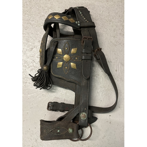 1389 - A vintage Shire horse heavy leather bridle with blinkers and fringed headpiece. Brass decoration and... 