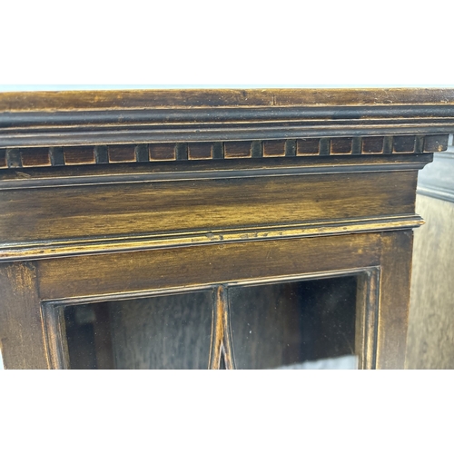 1393 - A pair of vintage dark wood wall hanging cabinets with glazed doors. With carved dentil design moldi... 