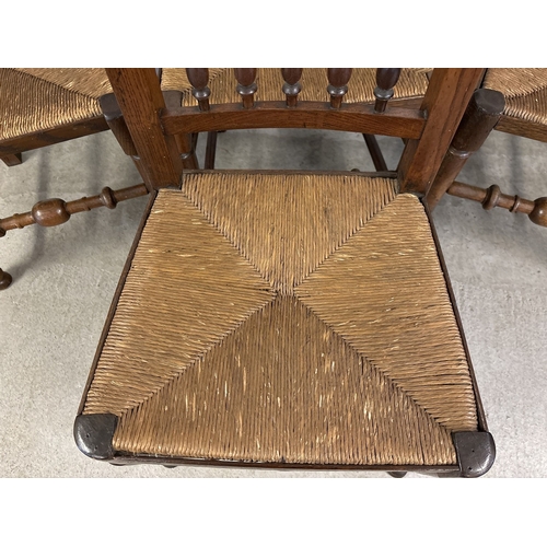 1468 - A set of 4 matching antique Lancashire spindle back chairs with rush seats and dark oak frames. With... 