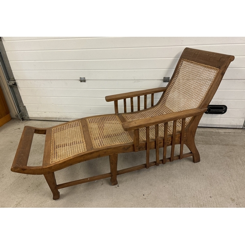 1476 - A vintage colonial style wooden framed lounger with woven cane seat. Approx. 180cm long.