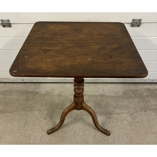 1485 - An antique walnut tilt top table with turned pedestal column and raised on tripod feet. Square shape... 