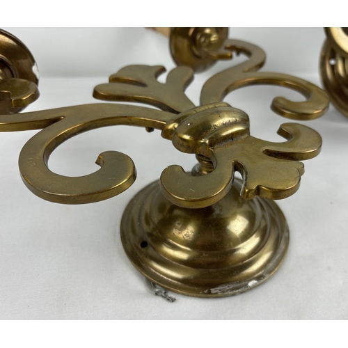 1202 - A pair of vintage Gothic style double wall sconces. Fleur De Lis design body with faux candle bulb h... 