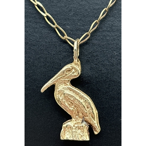 1010 - A 9ct yellow gold pelican pendant on an 18