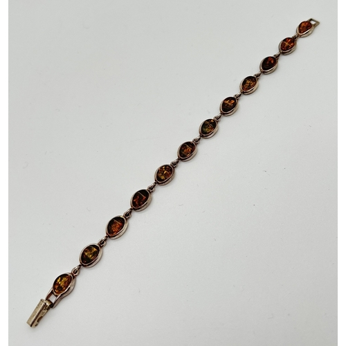 1013 - A silver and green amber bracelet with clip clasp. Each link an oval piece of amber in a silver beze... 