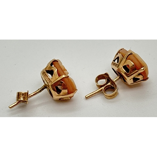 1018 - A pair of 9ct gold stud earrings set with small oval cameos in pierced work mounts. Hallmarked on mo... 