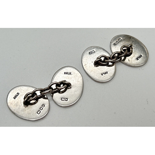 1027 - A pair of vintage silver oval shaped cuff links with engine turned decoration. Hallmarked for London... 