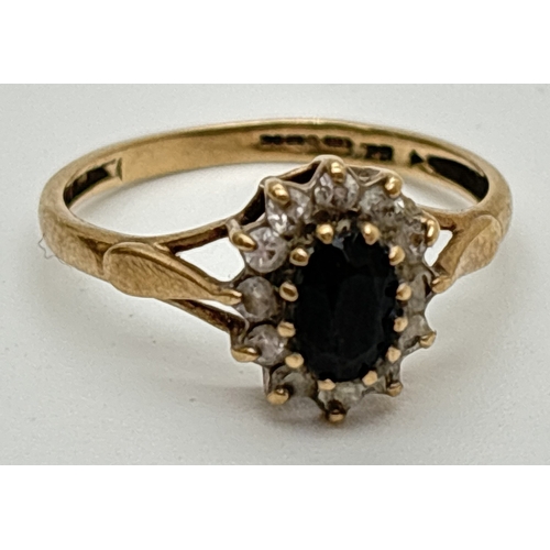 1035 - A 9ct gold sapphire and cubic zirconia cluster style ring with split design shoulders. Central oval ... 