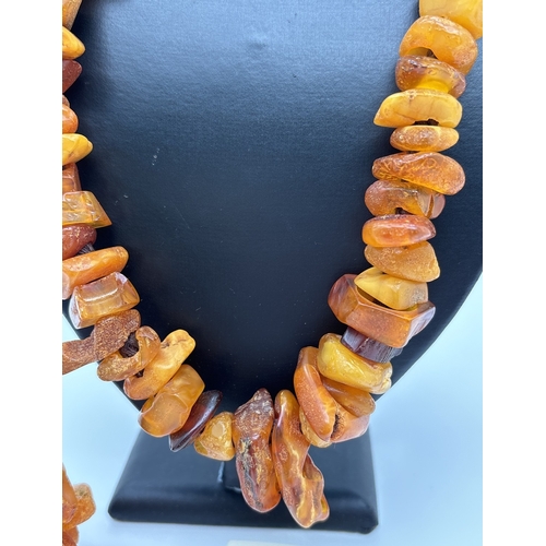 1006 - An amber modern design statement necklace and matching drop earrings by The Dezzler Collection. Made... 