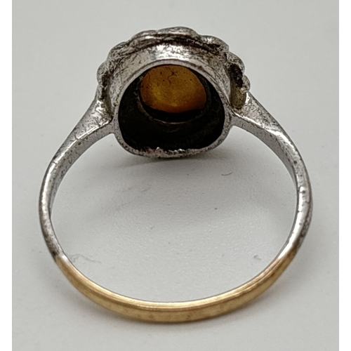 1060 - A vintage silver & 9ct gold ring set with central oval yellow gold foil glass cabochon. Surrounded b... 