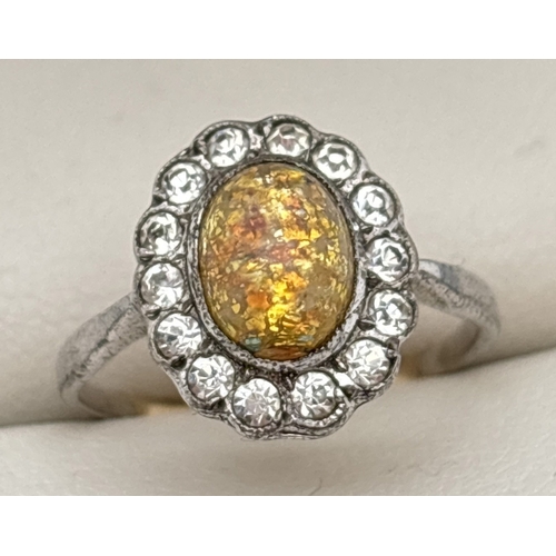 1060 - A vintage silver & 9ct gold ring set with central oval yellow gold foil glass cabochon. Surrounded b... 