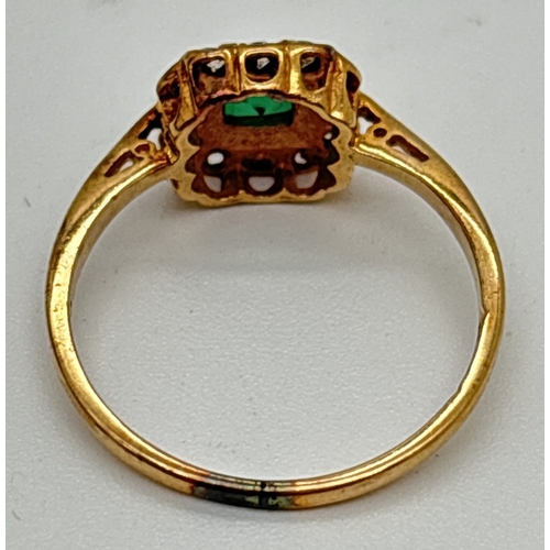 1063 - A 9ct gold created emerald and clear stone cluster style ring. Central square cut emerald surrounded... 