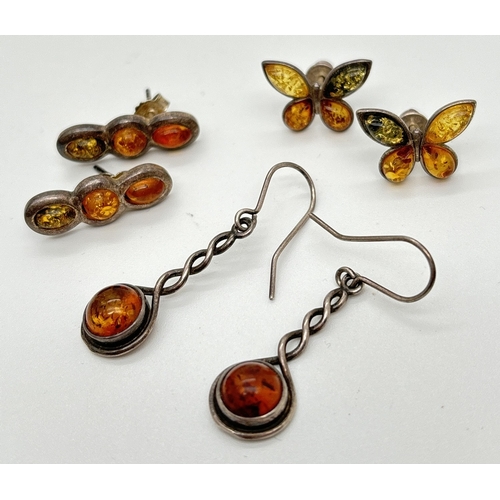 1066 - 3 pairs of amber set silver and white metal earrings. A pair of 3 stone studs set with honey and gre... 