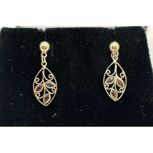 1084 - A pair of yellow gold leaf design drop earrings, each set with 3 small marquise cut garnets. 9ct gol... 