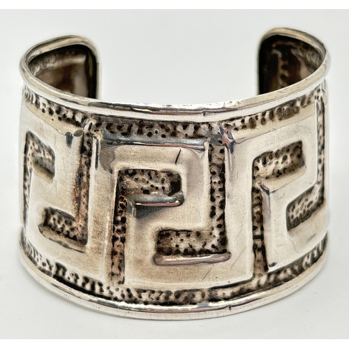 1085 - A large hammered effect cuff bangle with Greek key embossed decoration. 925 stamped on both rims. Ap... 