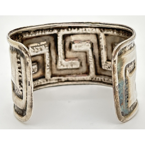 1085 - A large hammered effect cuff bangle with Greek key embossed decoration. 925 stamped on both rims. Ap... 