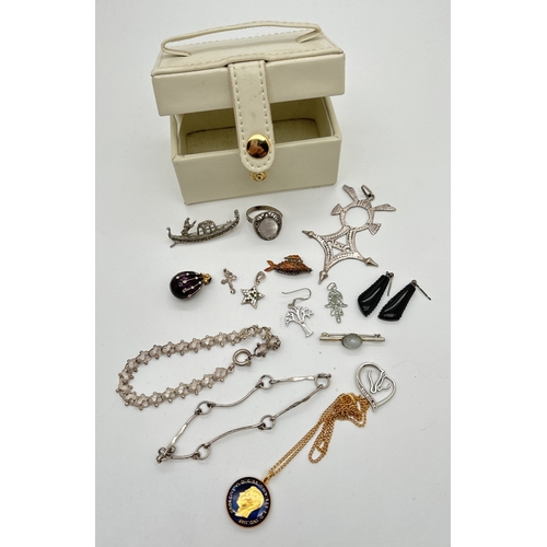 1086 - A small white faux leather travel jewellery box containing a small quantity of silver, white metal a... 