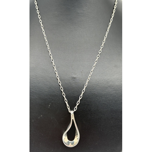 1087 - A silver open teardrop style pendant on a 20