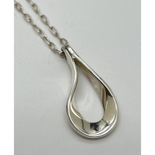 1087 - A silver open teardrop style pendant on a 20