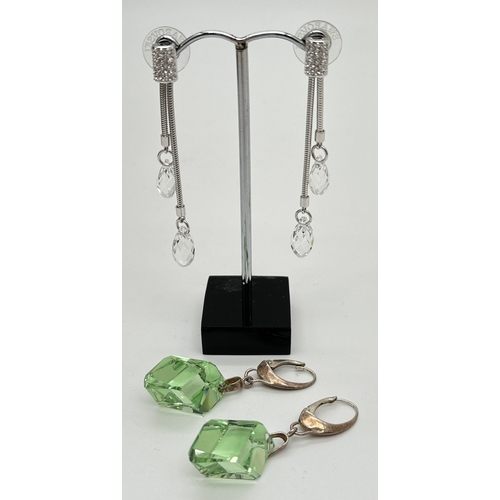 1088 - 2 pairs of crystal drop earrings. A pair of Swarovski silver tone double drop earrings with 2 facete... 