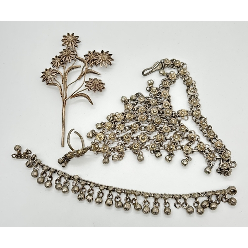 1089 - An Indian Hathphool ring hand bracelet with silver floral links and small bells, together with an an... 