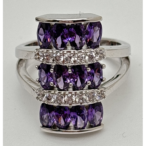 1092 - A rhodium plated baguette shaped cocktail ring set with Swarovski crystals. 3 rows of 4 oval cut pur... 