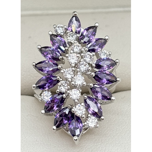 1093 - A large rhodium plated costume jewellery cocktail ring set with Swarovski crystals. A large floral d... 