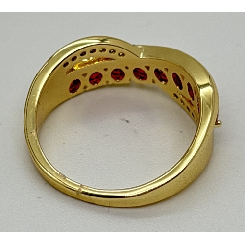 1098 - A yellow gold plated crossover cocktail ring set with round cut red and clear Swarovski crystals. 8 ... 