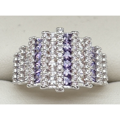 1099 - A rhodium plated cathedral style cocktail ring set with alternating rows of purple & clear Swarovski... 