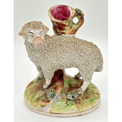 1228 - A 19th century Staffordshire sheep spill vase with gilt detail and tufted grass to base and rim of v... 