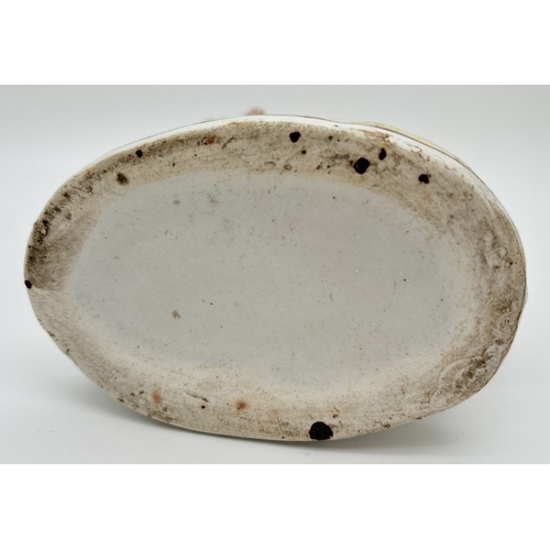 1228 - A 19th century Staffordshire sheep spill vase with gilt detail and tufted grass to base and rim of v... 