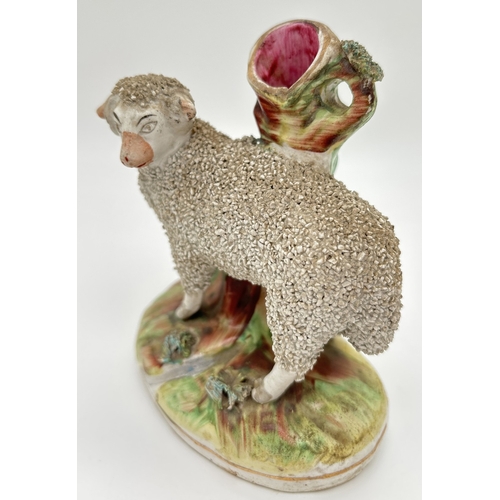 1228 - A 19th century Staffordshire sheep spill vase with gilt detail and tufted grass to base and rim of v... 