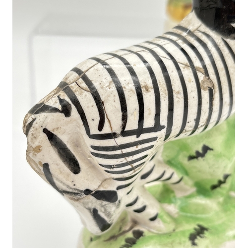 1229 - 3 Staffordshire 19th century figures. A sponge finished black and white horse spill vase, a flat bac... 