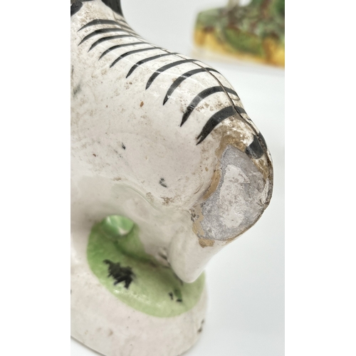 1229 - 3 Staffordshire 19th century figures. A sponge finished black and white horse spill vase, a flat bac... 