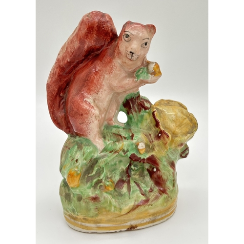 1233 - A Staffordshire pottery figure of a red squirrel on an oak tree. Some flaking to paintwork, small ch... 