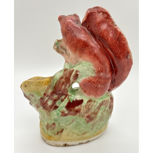 1233 - A Staffordshire pottery figure of a red squirrel on an oak tree. Some flaking to paintwork, small ch... 