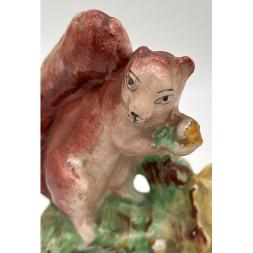1233 - A Staffordshire pottery figure of a red squirrel on an oak tree. Some flaking to paintwork, small ch... 