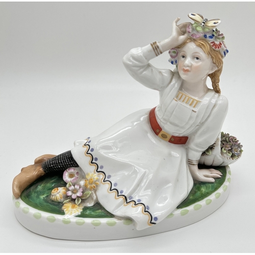 1239 - A German porcelain figure of a girl sitting on the grass with a butterfly in her hair, by Karl Ens V... 