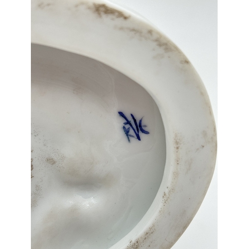 1239 - A German porcelain figure of a girl sitting on the grass with a butterfly in her hair, by Karl Ens V... 