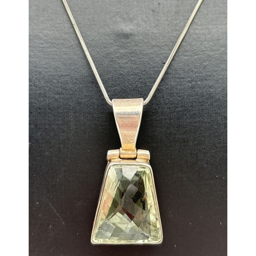 1107 - A silver & green amethyst pendant necklace. Pendant set with a trapeze cut pale green amethyst in a ... 