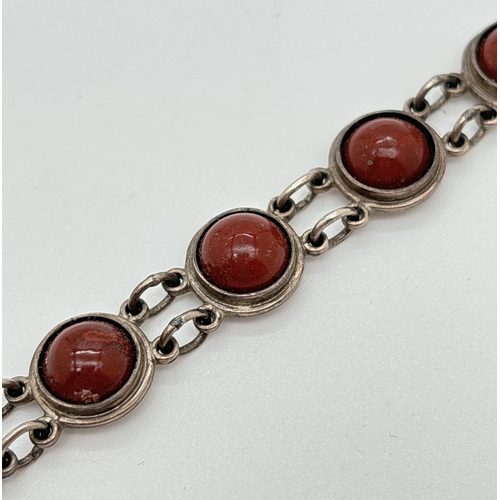 1119 - A 950 silver circular link bracelet set with cabochons of red jasper. With pin and plate clasp, stam... 