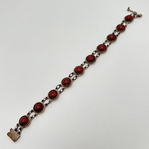 1119 - A 950 silver circular link bracelet set with cabochons of red jasper. With pin and plate clasp, stam... 